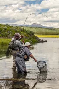 Fly fishing scene on the Henry’s Fork River with angler and net, fine art photography print by Clint Losee