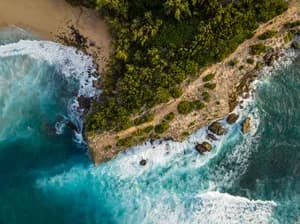 Aerial coastal landscape of Kauai, Hawaii with tropical greenery and golden shoreline, fine art photography print by Clint Losee