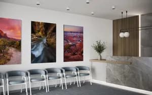 Three vertical fine art landscape prints featuring Southwest red rock canyons hanging in a modern office lobby setting.