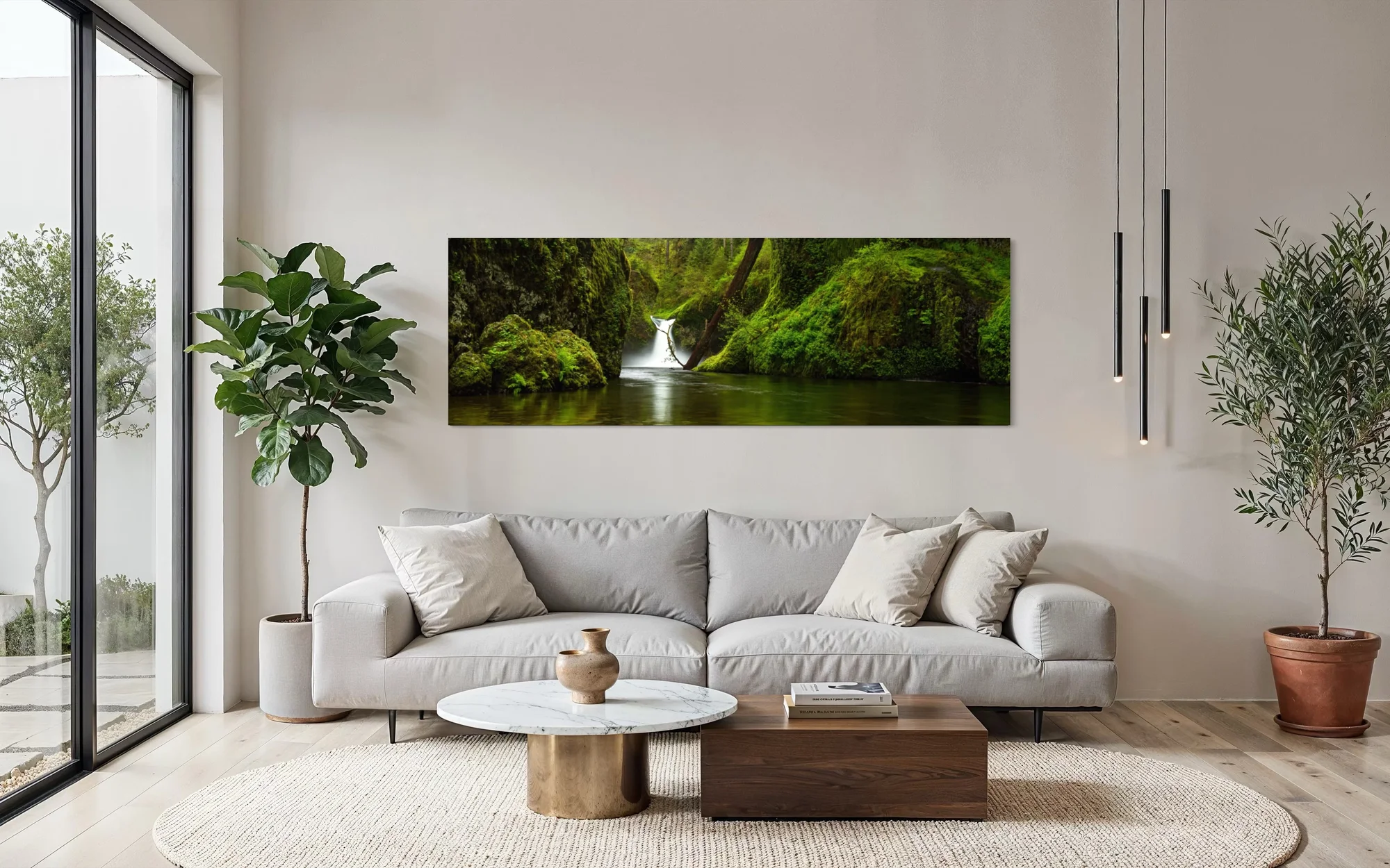 Large panoramic fine art print of a lush green waterfall and mossy stream displayed above a sofa in a modern living room.