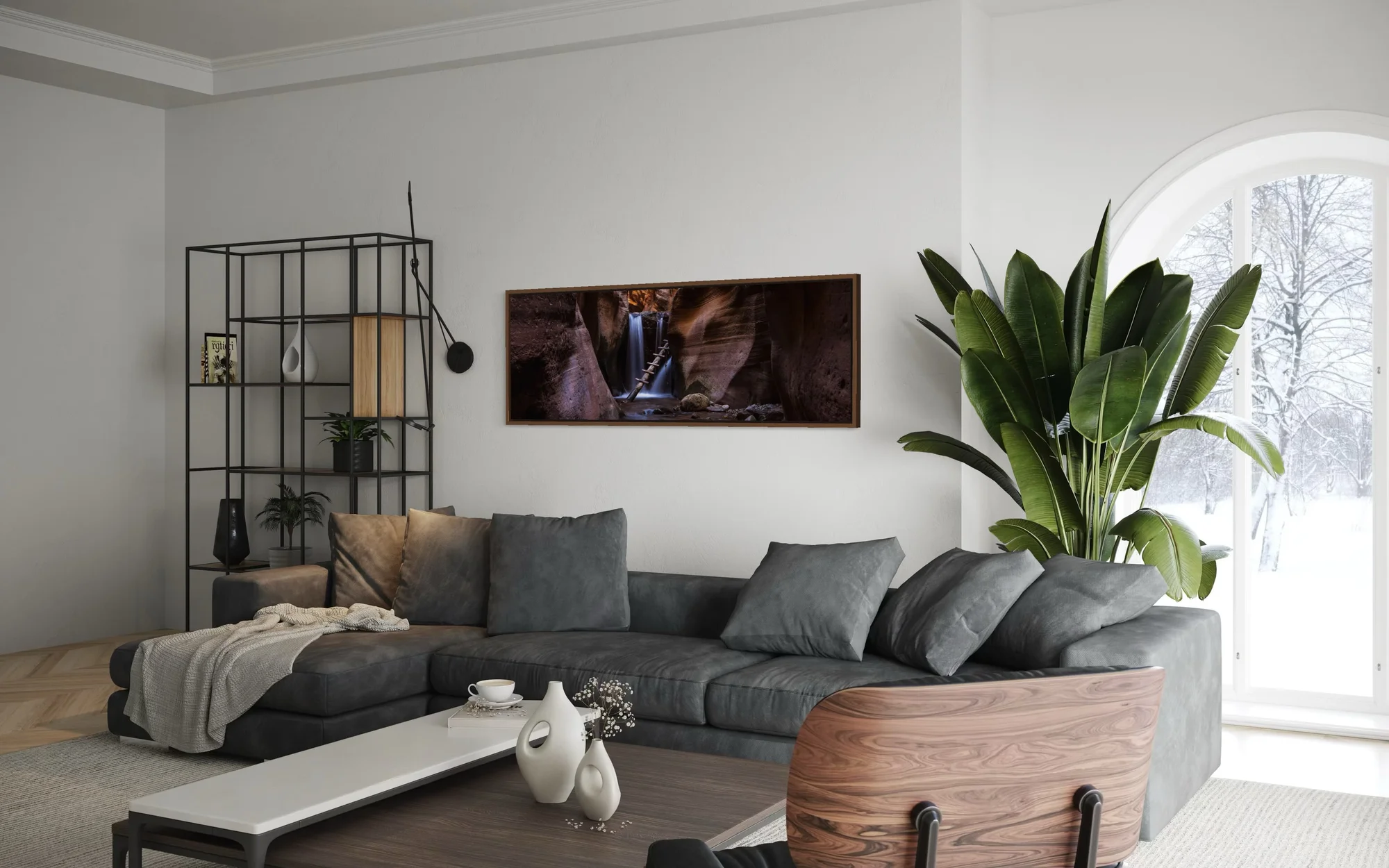 Panoramic fine art print of a waterfall inside a slot canyon mounted above a charcoal sofa in a modern living room.