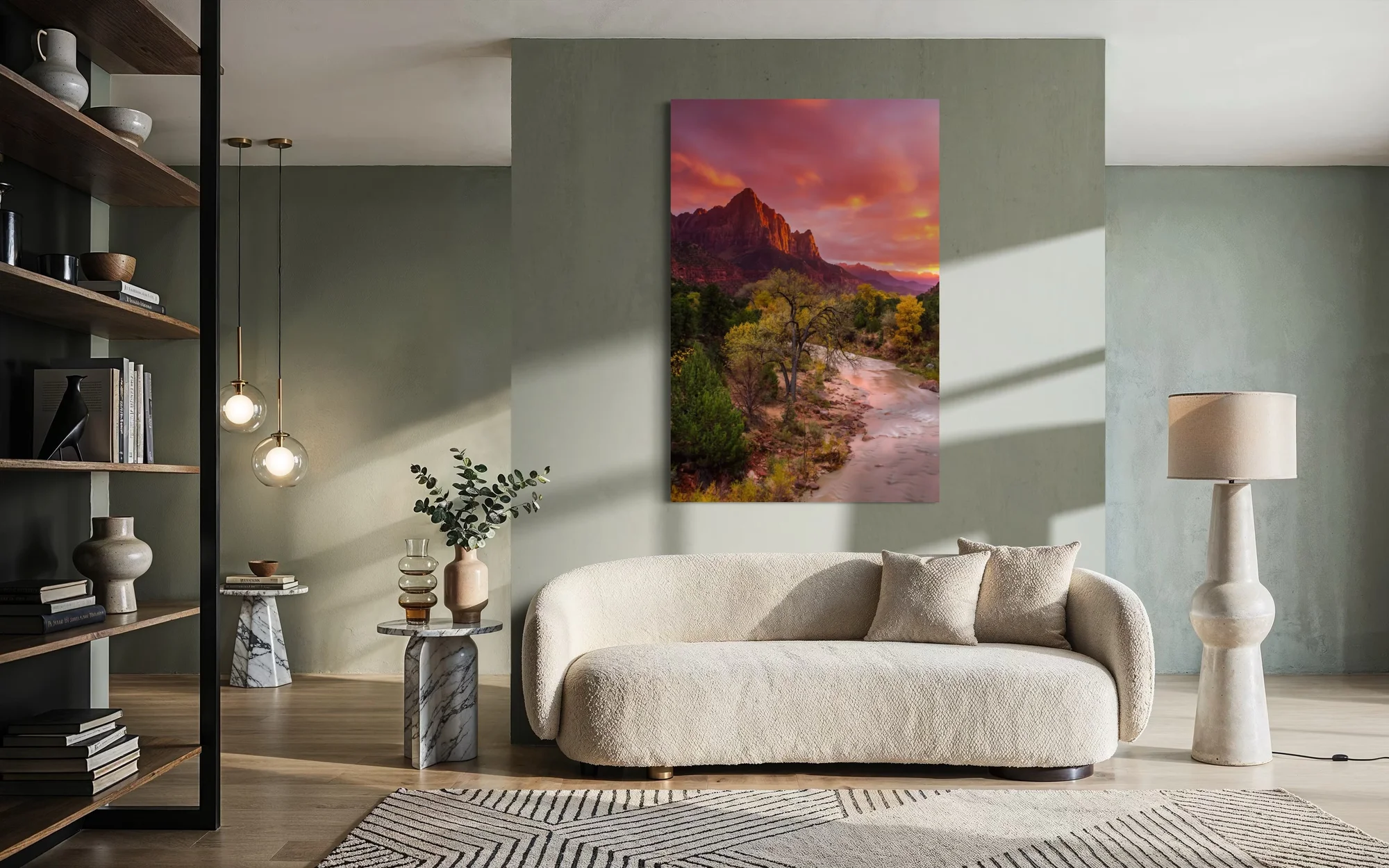 Large fine art print of a sunset over The Watchman peak in Zion National Park displayed above a couch in a modern living room.